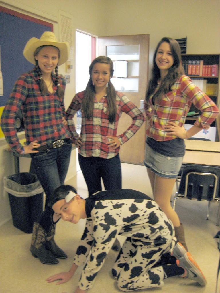 Freshmen cowgirls Jackie Hoege, Madison Myers and Alexis Duday make sure they keep freshman cow Dylan Henderson in line. The students unplanned thematic costumes were for Thursdays Costume Day. 