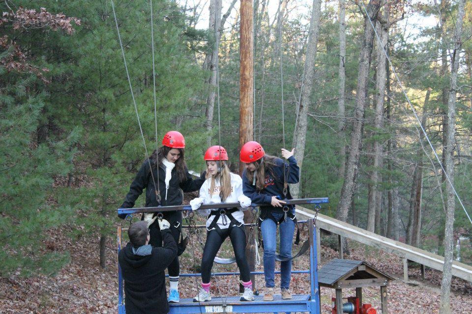 Lacey Gagg, Marissa Phillips, and Rachel Kerl reach for the sky on a free-fall swing at the Young Life Fall Weekend.