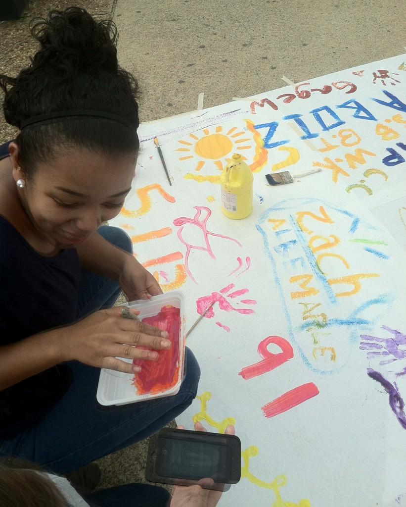 Sophomore Mia Murray finger paints on the mural for Latino Heritage Month. 