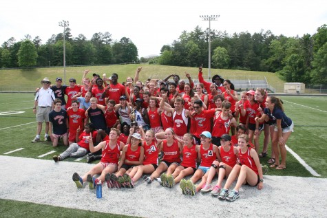 The track team celebrates after the boys narrowly won the conference meet.