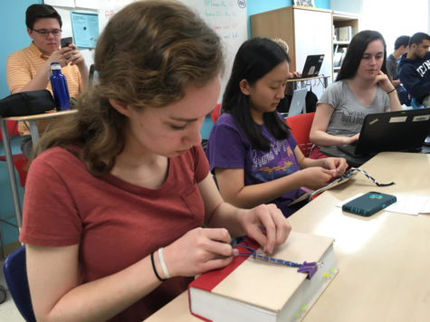Juniors Mattie Wiseman and Emma Kim make friendship bracelets in their English class. Wiseman has made five bracelets so far this year.