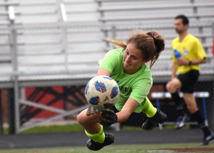 Senior goalie Jaya Daniels stretches to stop a ball during a pre-game practice in 2019. 