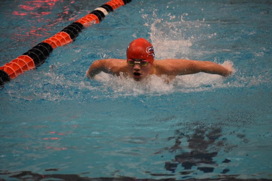 Sophomore Connor Marshall jumps out of the water during the boys 100 butterfly. Marshall came into the wall with a time of 54.99 seconds, placing first in Heat 1. Marshall finished fifth overall.