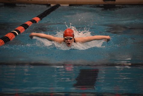 Freshman Sara Wells pushes through the water in the girls 100 butterfly. Wells raced in Heat 3, finishing in the top ten overall with a time of 1 minute 3.45 seconds.