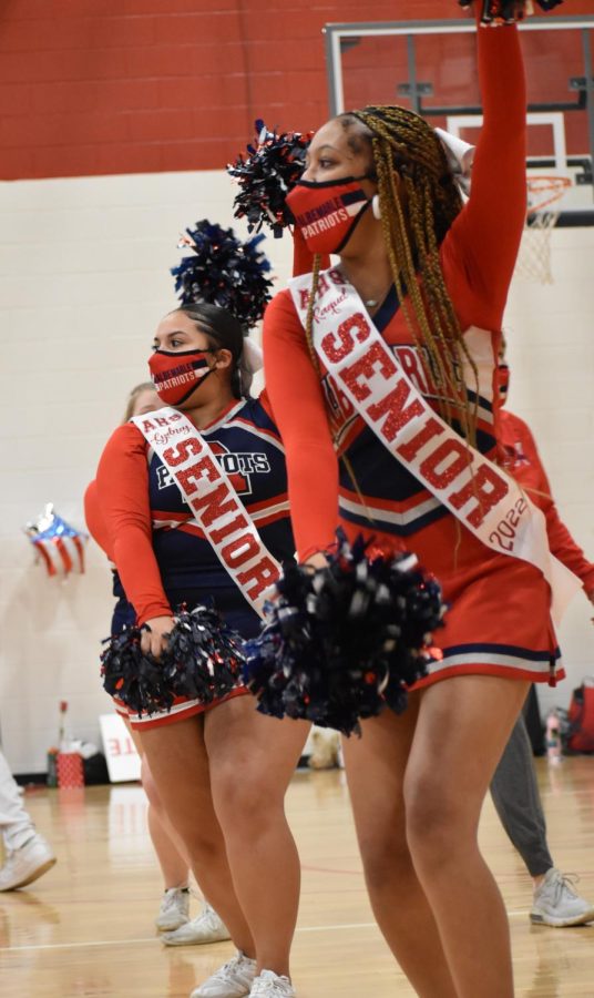 Seniors Raquel Courtney and Sydney Eubanks cheer the patriots on from the sidelines during the third quarter.