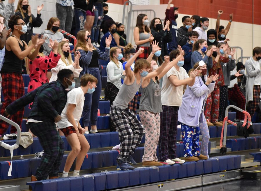 The student section, decked out in pajamas, cheer on the Patriots after a layup in the first half.