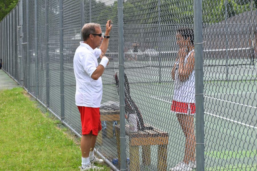 Assistant coach Don Paitrick speaks through the fence to Junior Amy Wang, offering guidance in between sets against Deep Runs fourth seed. 