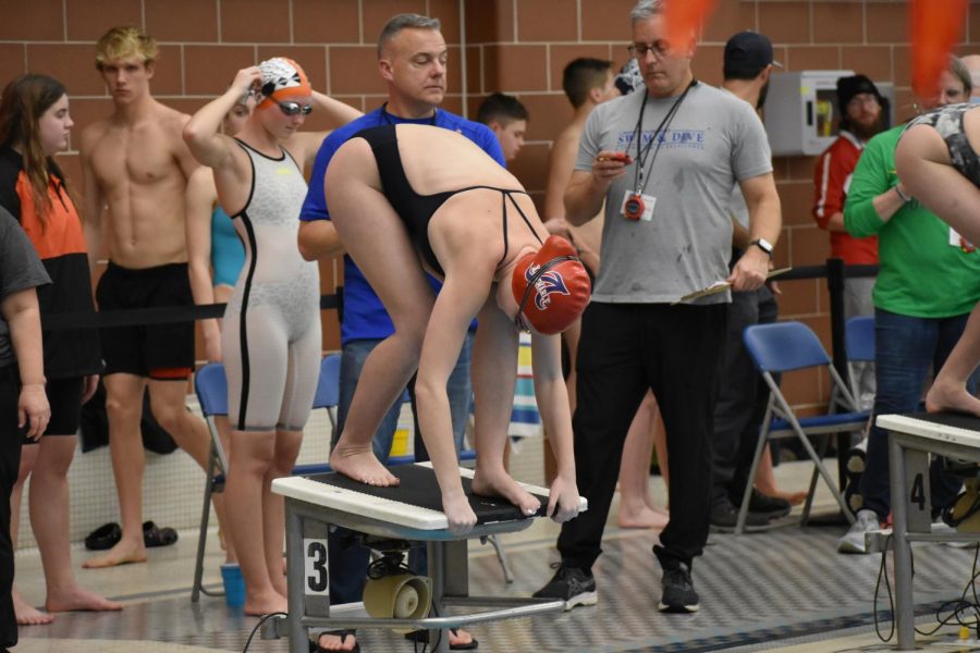 Junior Rachel Elhart prepares to dive into the water for heat five of the girls 100 freestyle race. 