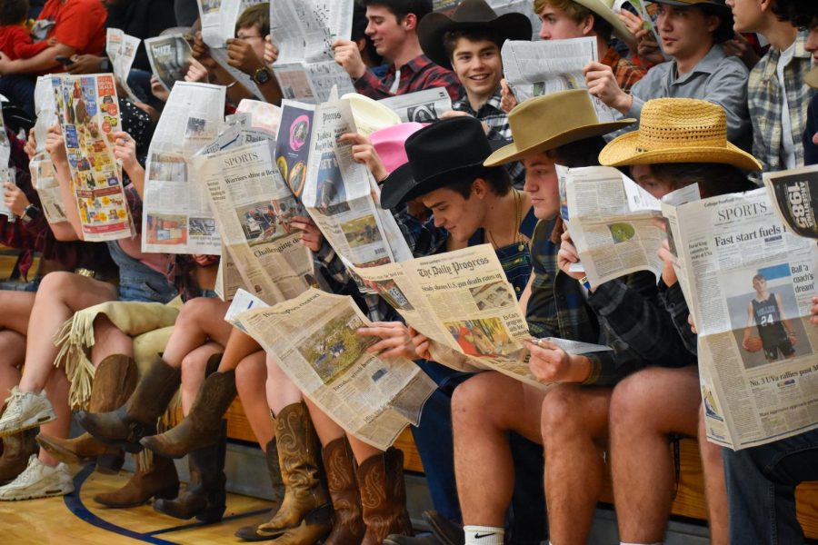Patriot fans read newspapers as Western players are announced at the beginning of the AHS vs WAHS game Friday night. 