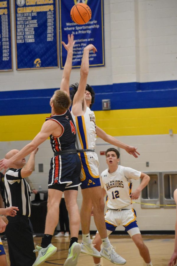 Senior Carter Wesson leaps up above Western opponent to fight for possession of the ball during the initial tip-off. 