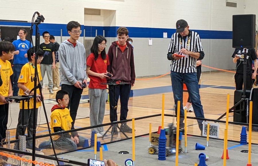 Firefly team members, sophomores Daniel Cao and Claire Ke and senior captain Will Terrell, steer their robot to pick up plastic cones to place them on different levels of poles. The FTC challenge is different each year. 