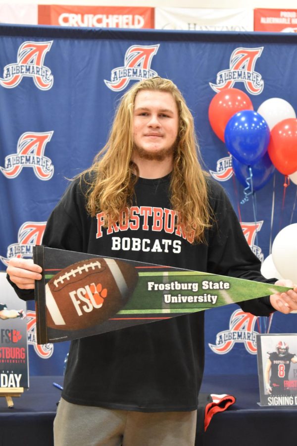 Senior Malekye Hicks smiles with his college flag on signing day. He will attend and play football for Frostburg State University.