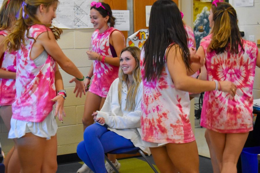 Wearing hot-pink tie-dye shirts, Cupid’s Cuties spin around junior Cameron Smith.