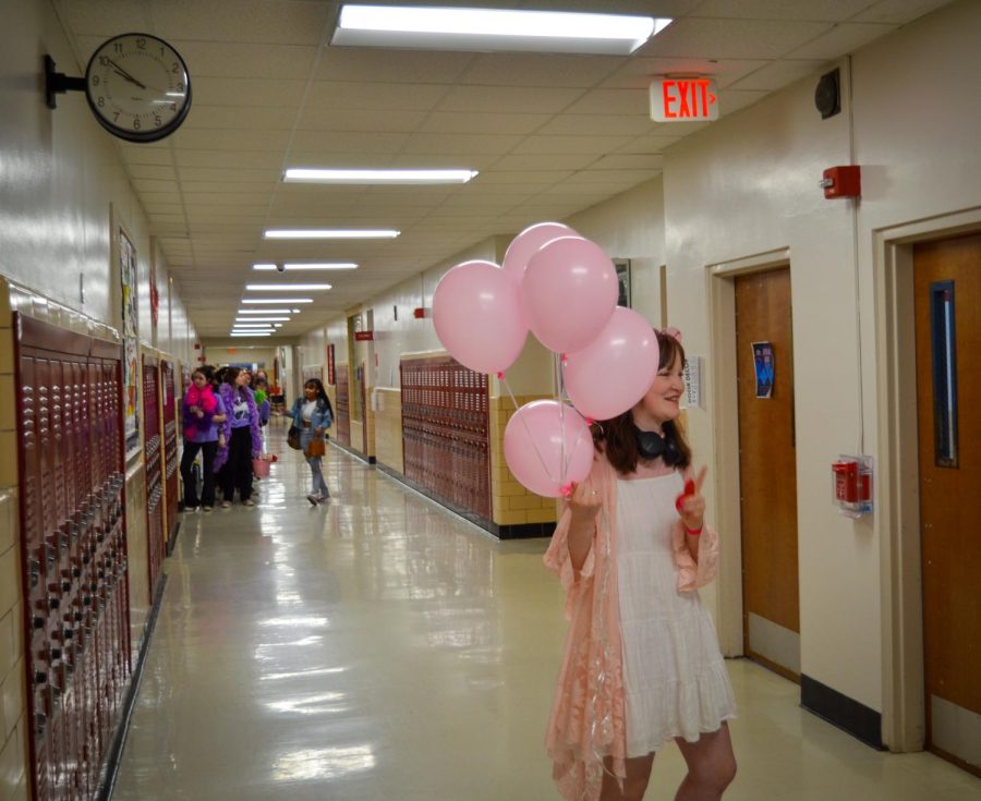 9th grader Maggie Graham grasps pink balloons ready for delivery.