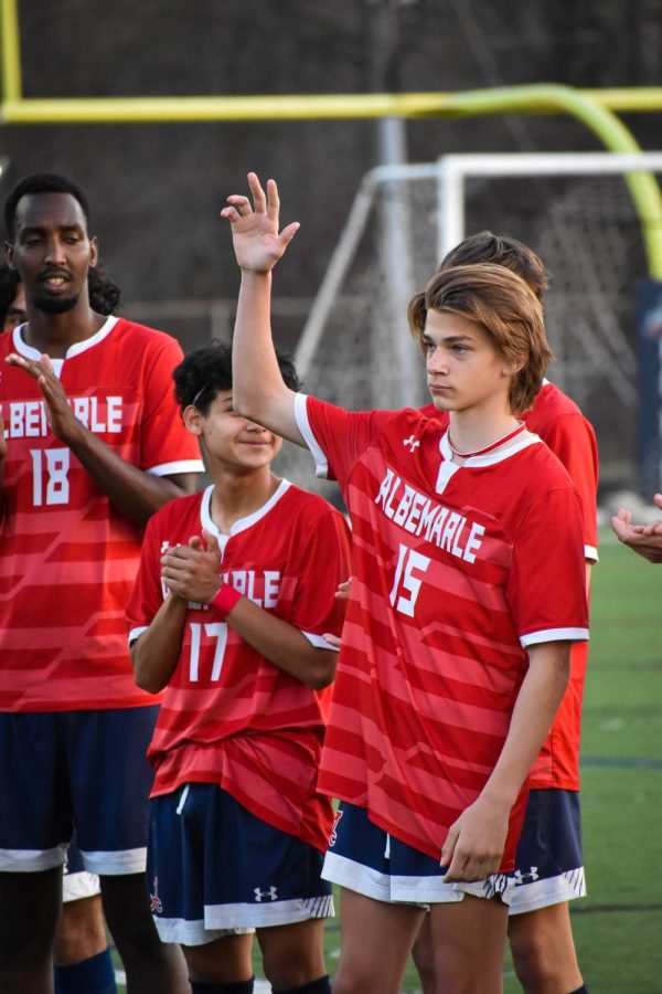 9th grader Devin Kriebel raises his hand in front of the crowd when he is announced before the game.