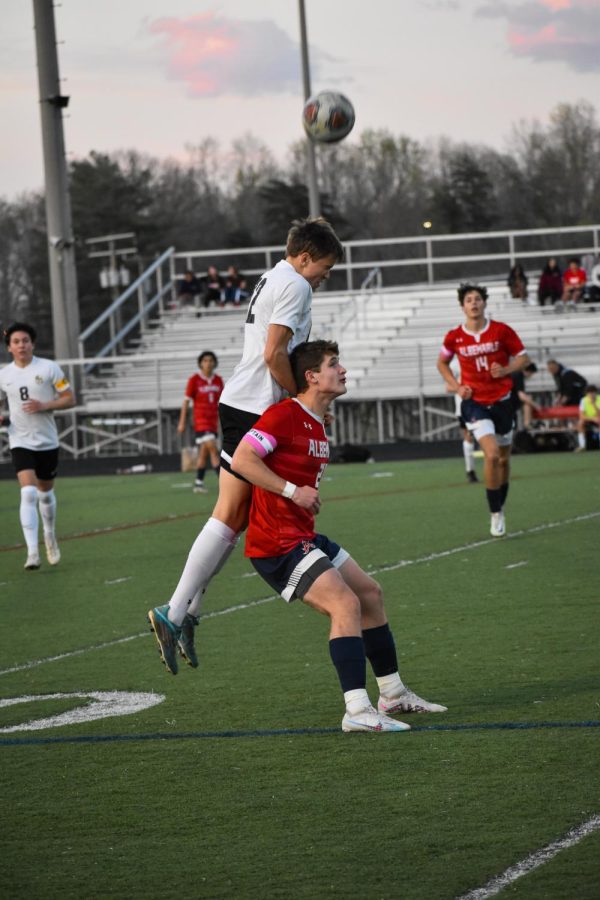 Monticello player jumps above junior captain Jack Dofflemyer to complete a header. AHS got possession once the ball hit the ground.