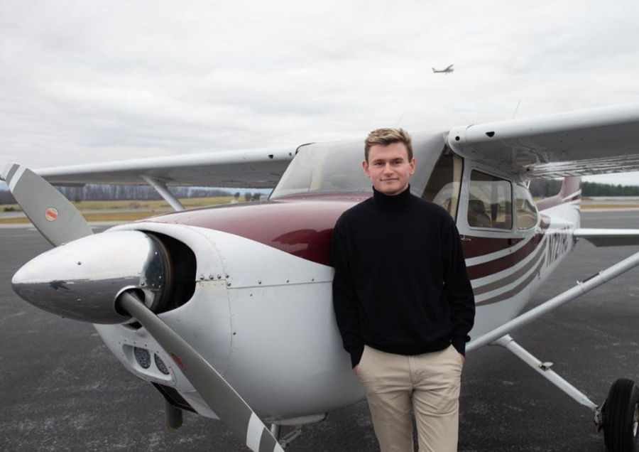 Senior Graham DeVito leans against a small plane at Shenandoah Valley Airport. He plans to fly commercially once he graduates.