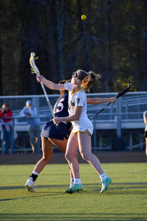 Exploding upward, Junior Kelsey Kirkeide battles WAHS player during the first draw of the game. 