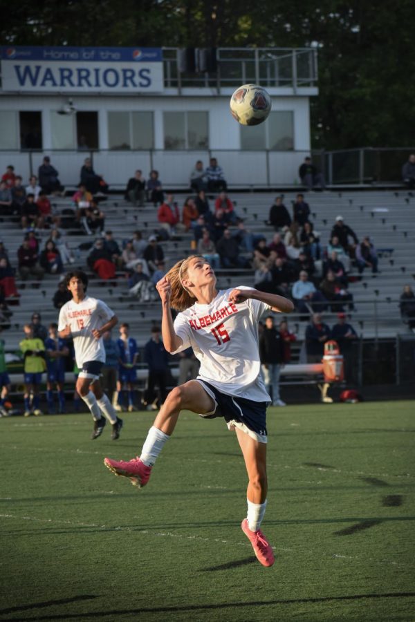 Leaping into the air, 9th grader Devin Kriebel receives the ball head-on, passing it to a teammate. 