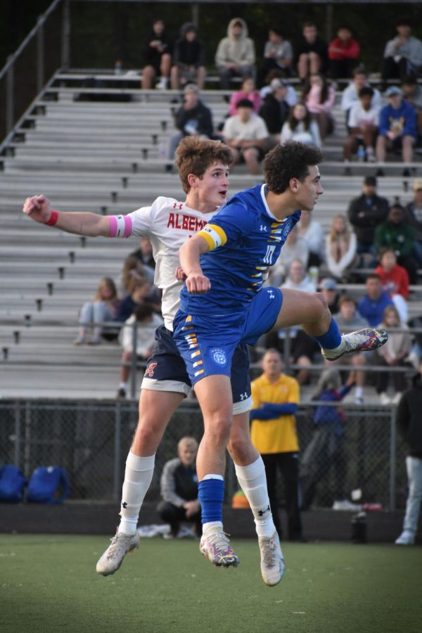 Battling with WAHS player in the air, junior captain Jack Dofflemyer prepares to receive a long kick with his head. 