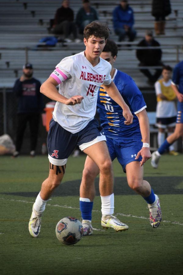 Senior captain Luke McClung keeps control of the ball in the midfield, looking for a pass as a Western player comes up behind him. 