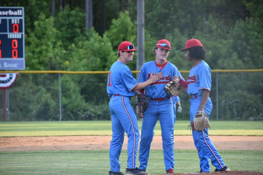 Pitcher Mandela Browman huddles up with Grant Shiflett and Will Coleman before going through with the next play.