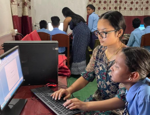 Sophomore Aarushi Shah works with a Nepali student during her computer literacy workshop. Photo courtesy of Apan Foundation. 