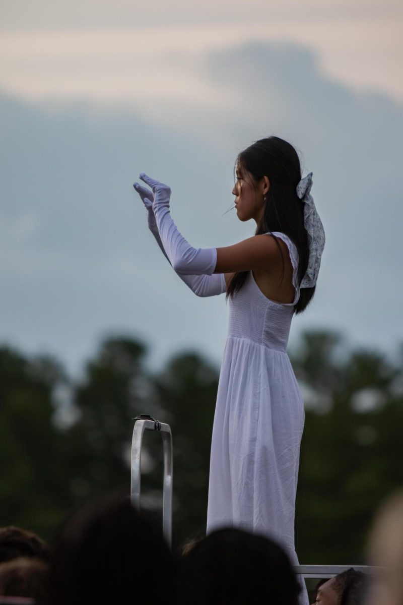 Senior drum major Annie Meng conducts the marching band during the Aug. 25 home football opener. 