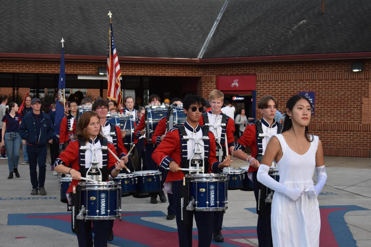 Senior drum major Annie Meng leads the marching band into the stadium before the Homecoming game.