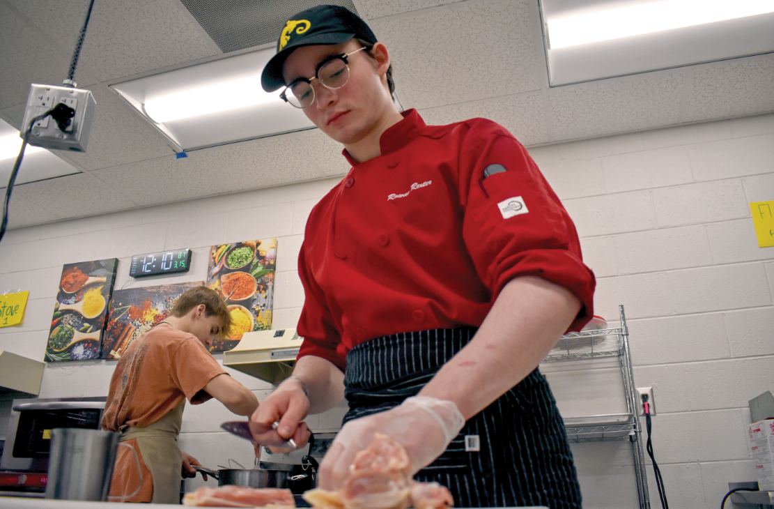 Senior Rowan Rexter chops chicken for his mystery box challenge on March 15. 