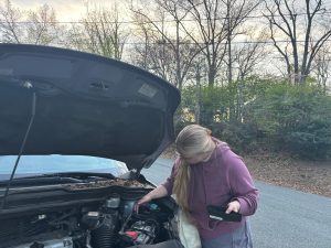 Junior Kenzie Dessert checks the fuse box on her sister's car  in order to figure out why the turn signal won't turn off.  Photo courtesy of K. Dessert. 